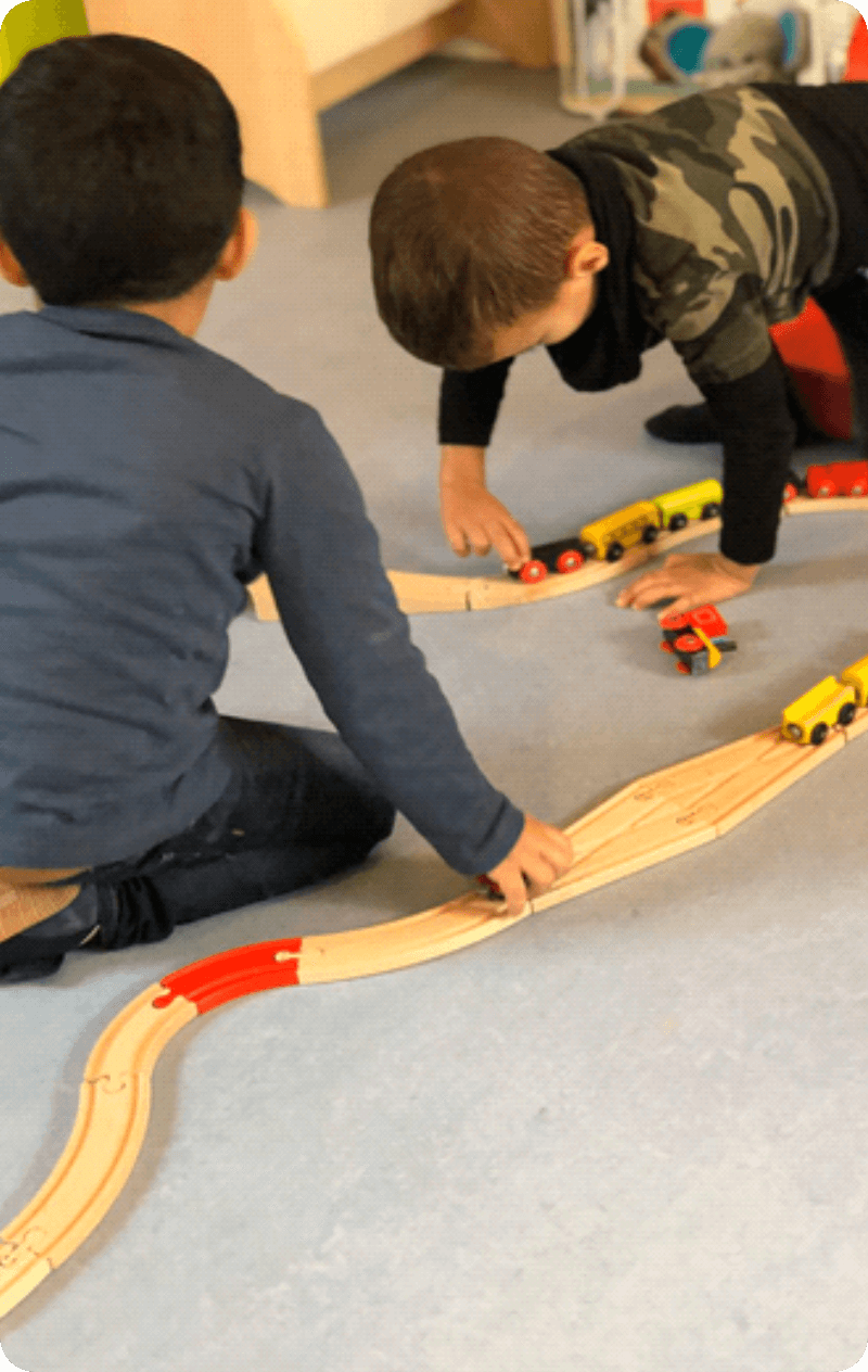 Twee kinderen spelen met de treinbaan.